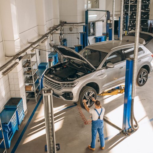 Auto mechanic checking car