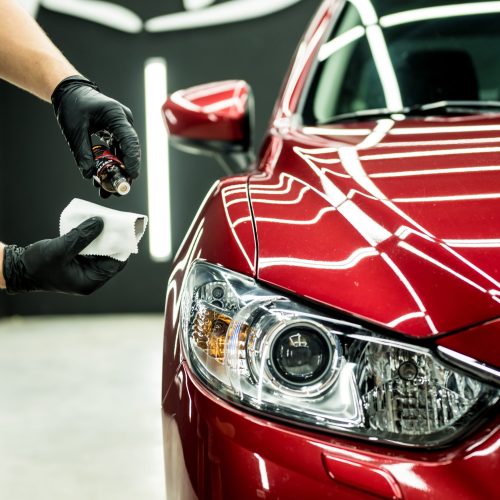 Car service worker applying nano coating on a car detail